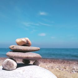 Rocks on beach against blue sky