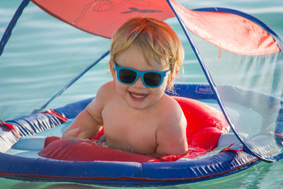 Portrait of cute boy with inflatable ring in sea