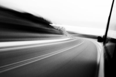 Blurred motion of car on road against sky