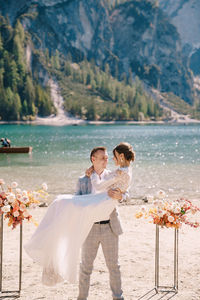 Couple kissing while standing at riverbank