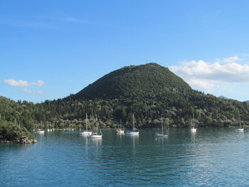 Scenic view of sea and mountains against blue sky