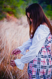 Rear view of woman standing on field