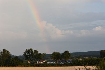 Scenic view of rainbow over landscape against sky