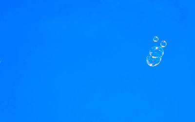 Close-up of bubbles against blue sky