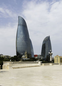 Modern buildings in city against cloudy sky