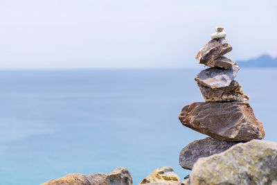 Stack of rocks in sea against sky