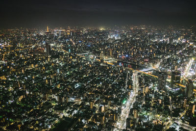 Illuminated cityscape against sky at night