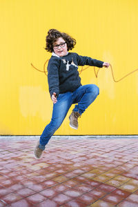 Portrait of man jumping against wall