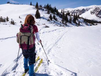 Young woman cross-country skiing in raxalpe mountains, austria