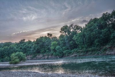 Scenic view of river against cloudy sky