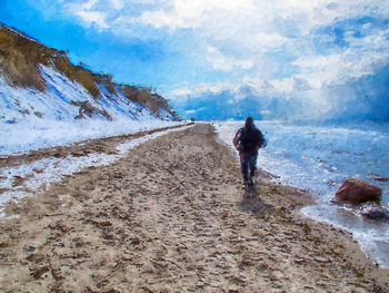 Rear view of man walking on land against sky