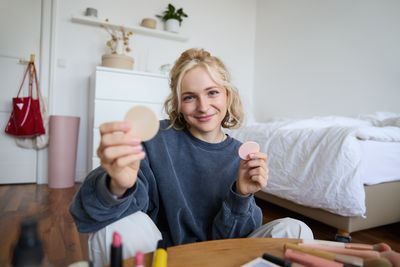 Portrait of young woman sitting on table