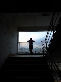 Rear view of man standing on staircase