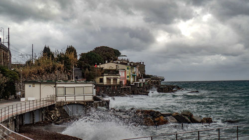 Built structure by sea against sky