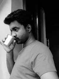 Side view of young man drinking coffee