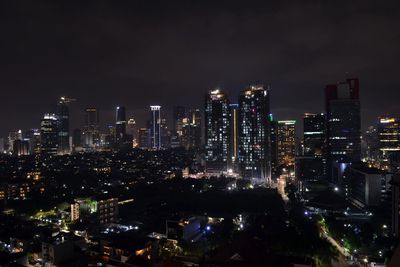 Illuminated buildings in city against sky at night