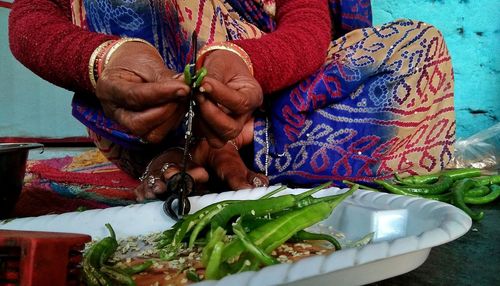 Midsection of woman holding chili pepper