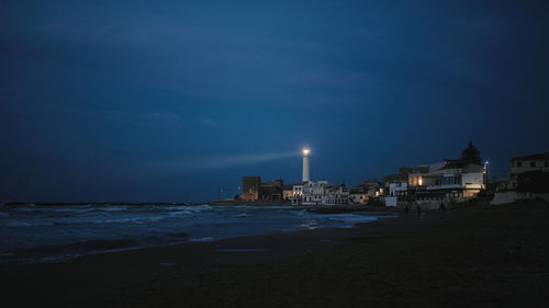 Lighthouse on the beach in the night