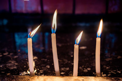 Close-up of candles burning against building