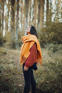 Rear view of woman standing in forest