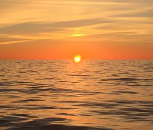 Scenic view of sea against orange sky