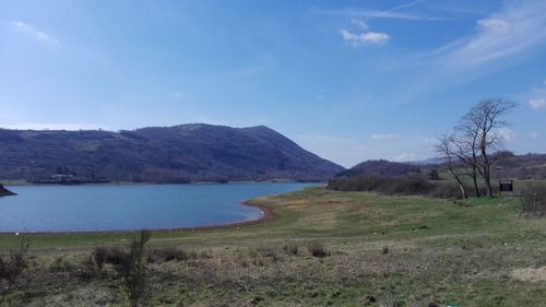 Scenic view of landscape by sea against sky