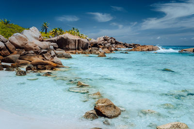 Scenic view of rocks in sea against sky