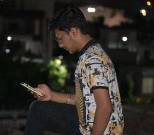 Side view of teenager using mobile phone