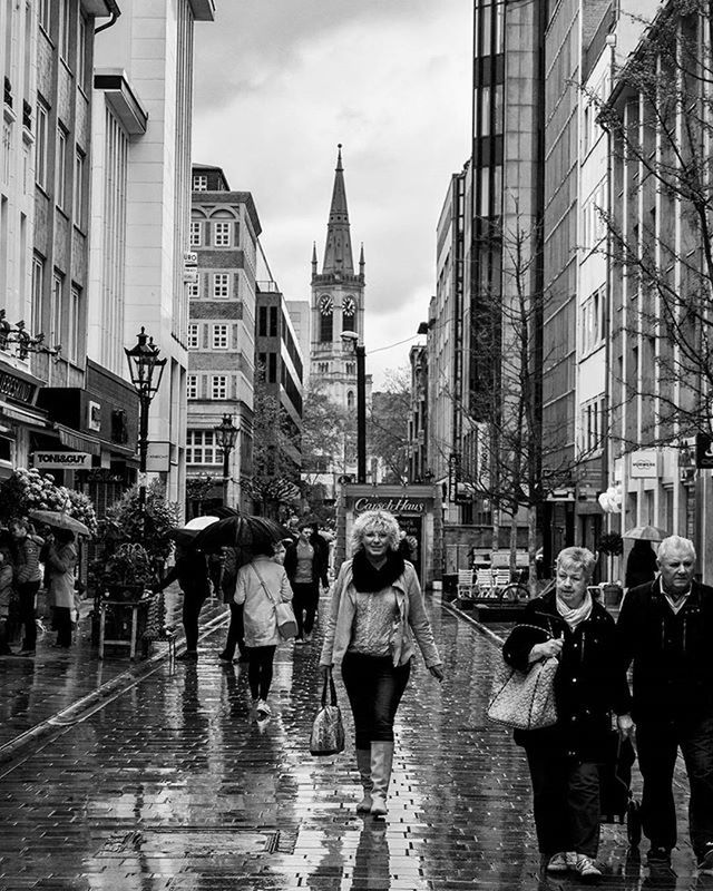 building exterior, architecture, built structure, city, men, street, person, walking, large group of people, city life, lifestyles, building, sky, residential structure, leisure activity, residential building, the way forward, cobblestone, day