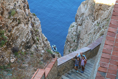 High angle view of people on rock by sea