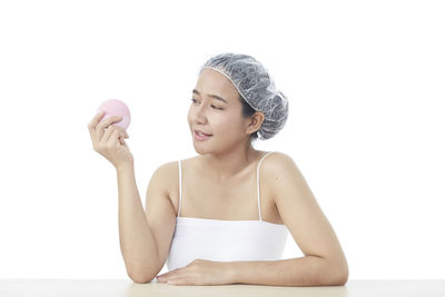 Portrait of young woman against white background