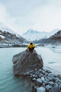 Man skiing on snowcapped mountain against sky