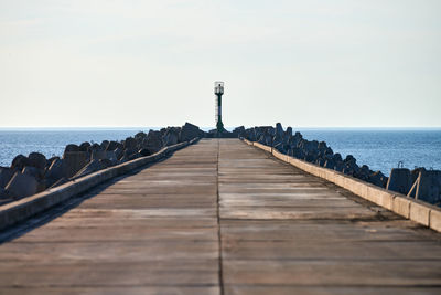 Empty long reinforced concrete pier with signal lighthouse in port somewhere in europe, copy space