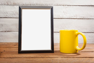 Close-up of coffee cup on table against wall