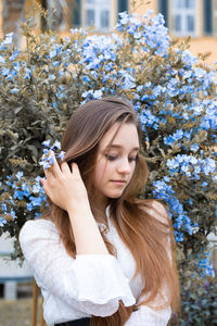 Close-up of young woman sitting against plants