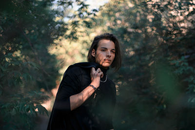 Young man standing in forest