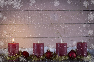 Close-up of christmas decoration on table against wood paneling