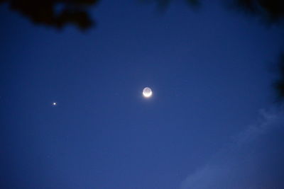 Low angle view of moon against clear blue sky