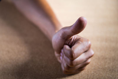 Close-up of person showing thumbs up