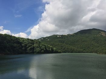 Scenic view of sea and mountains against sky