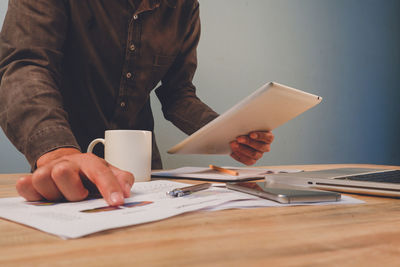 Midsection of man using laptop on table