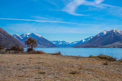 Scenic view of snowcapped mountains against blue sky