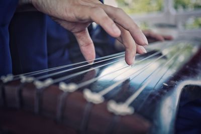 Midsection of man playing guitar