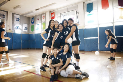 Happy teenage girls team at volleyball court