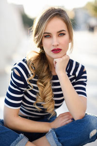 Portrait of young woman sitting outdoors