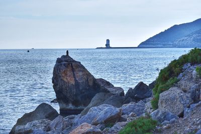 Rock formation in sea against sky