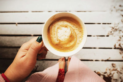 Cropped image of hand holding coffee cup