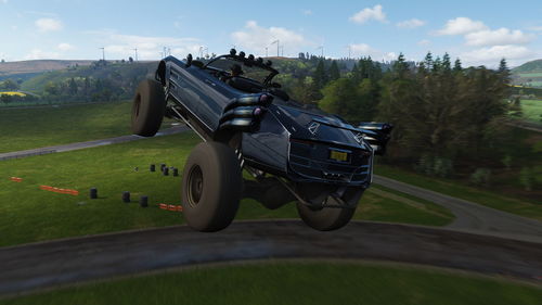 Car on road amidst field against sky