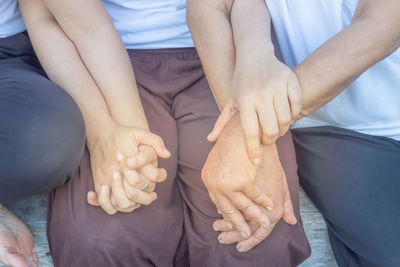 Midsection of people holding hands