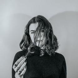 Close-up portrait of young woman against wall